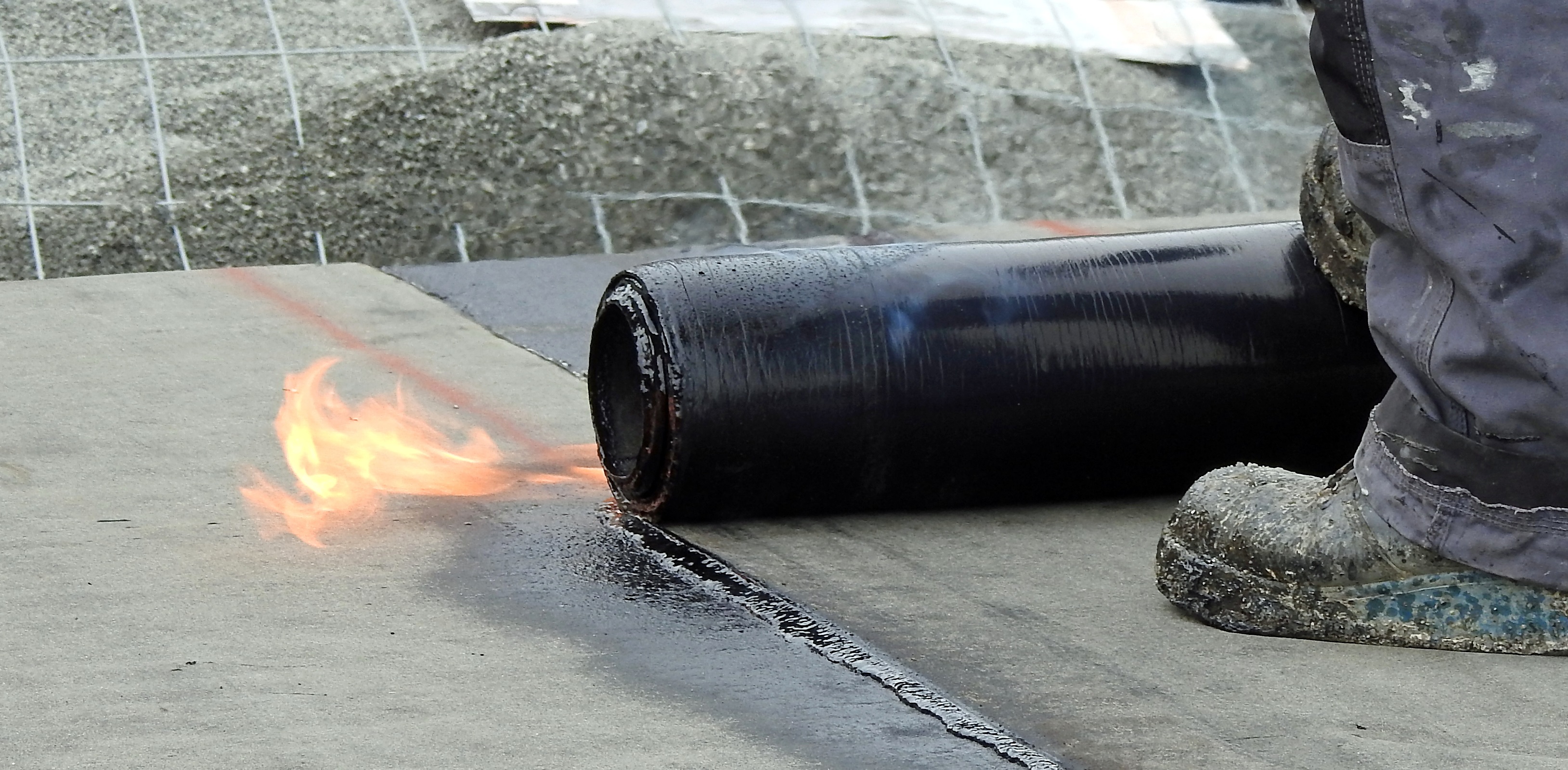 Man burning bitumen with a torch